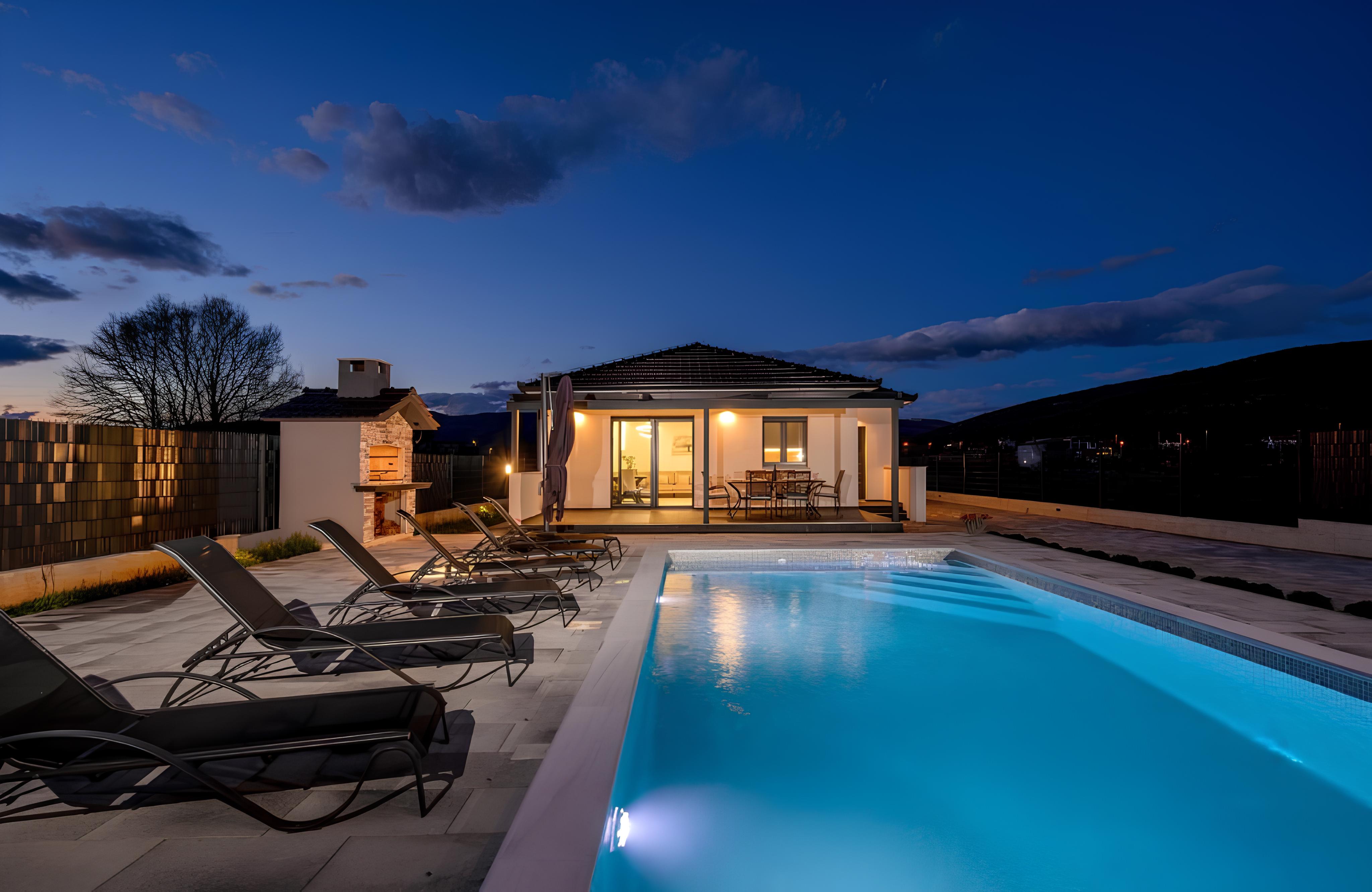 Decimum villa with heated pool at dusk, Dinaric Alps in the distance